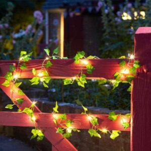 Solar powered artificial ivy with lights on a red garden gate.