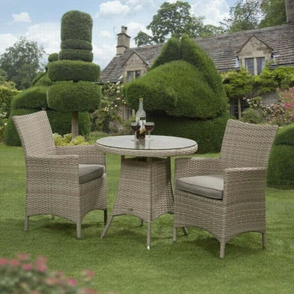 Rattan garden chairs with table in a garden.