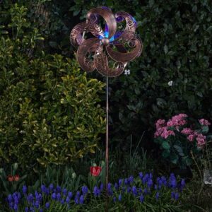 Metal wind spinner with light in a garden.