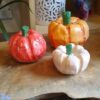 Three pumpkins made from clay in various sizes and colours.