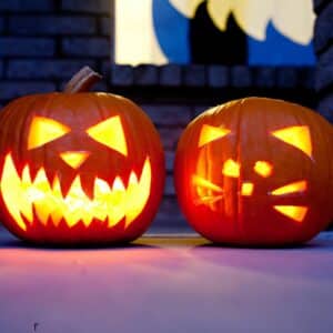 Two carved pumpkins with lights inside.