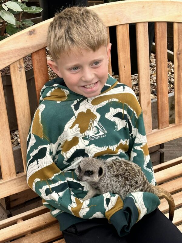 Child holding a meerkat